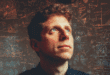 Sam Altman regardant vers un horizon brillant, avec des éléments visuels représentant l'IA en pleine évolution
