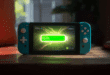 Une Nintendo Switch 2 posée sur une table, affichant un écran lumineux, avec une barre de batterie verte pleine à 100%, entourée d’une aura ou d’un éclair lumineux