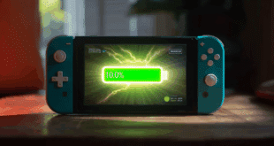 Une Nintendo Switch 2 posée sur une table, affichant un écran lumineux, avec une barre de batterie verte pleine à 100%, entourée d’une aura ou d’un éclair lumineux