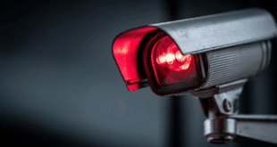 Une webcam allumée, avec une lumière rouge symbolisant la surveillance