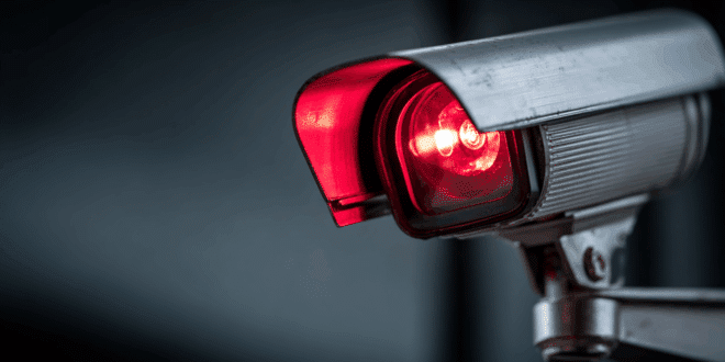 Une webcam allumée, avec une lumière rouge symbolisant la surveillance