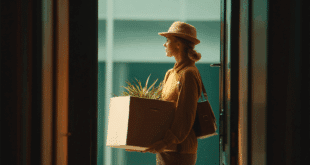 une femme renvoyé avec un carton avec ses affaires en train de sortir de son bureau