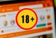 Une icône d'avertissement +18 devant un écran montrant l'interface de PornHub
