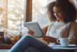 Une femme lisant un document .pdf professionnel sur une tablette dans son salon, illustrant l'accessibilité des fichiers PDF.