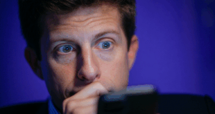 Une photo de Sam Altman inquiet, regardant son téléphone