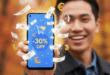 Un homme souriant et l'air satisfait, tient un Google Pixel 9a en main