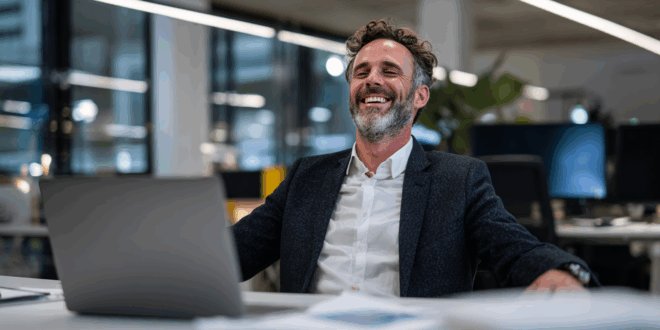 un homme content dans son bureau devant son laptop performant