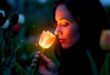 une femme sentant une tulipe lumineuse