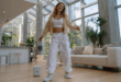 une femme en train de danser avec un téléphone Google pixel 9a et une enceinte JBL Go 3