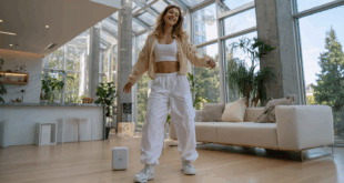 une femme en train de danser avec un téléphone Google pixel 9a et une enceinte JBL Go 3