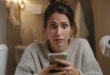 Une femme utilise son smartphone aux toilettes.