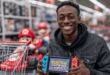 Une personne, l'air ravi, tenant une Nintendo Switch 2 avec les logos Pokémon ZA et Mario Kart