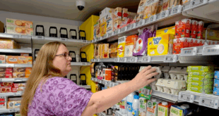 femme attrapant un produit dans une épicerie