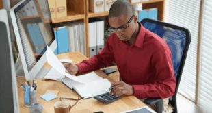 un homme dans son bureau vérifiant une facture