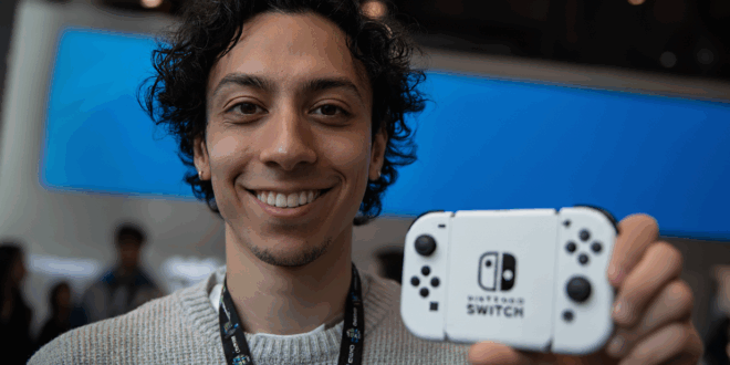 Un homme avec un Switch OLED à la main