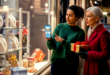 deux femmes regardant un téléphone devant une boutique