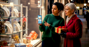 deux femmes regardant un téléphone devant une boutique