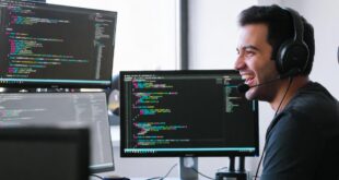Un développeur avec son casque à micro en train de coder
