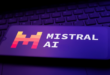 Un téléphone affichant le logo de Mistral AI sur un clavier de PC