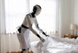 Un robot humanoïde majordome en train de ranger le lit