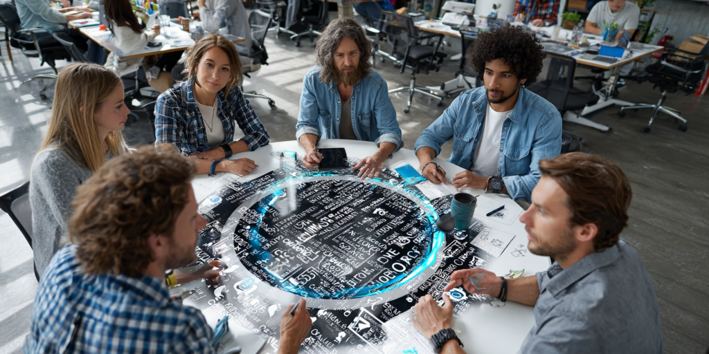 Équipe marketing en brainstorming de contenus réseaux sociaux autour d’une table digitale avec mots-clés lumineux et interface interactive.