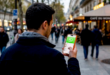 Homme tenant un iPhone affichant WhatsApp Plus