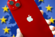 main tenant un iPhone,en arrière plan drapeau UE