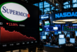 Écran affichant le logo Supermicro et une baisse de 13 % de son action au Nasdaq, sur fond de salle de marché